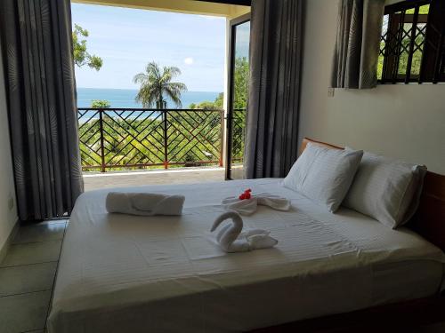 安塞罗亚莱Bougainvillas Seychelles的一间卧室设有一张床,享有海景