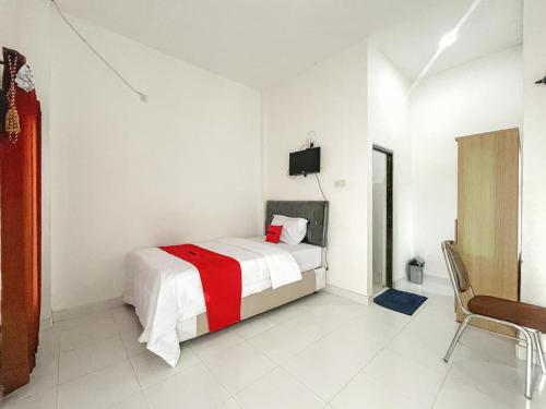 马塔兰RedDoorz Syariah near Siloam Hospital Mataram的白色卧室配有床和椅子