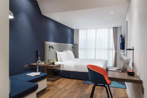 佛山佛山禅城智选假日酒店的酒店客房配有一张床、一张桌子和一把椅子。