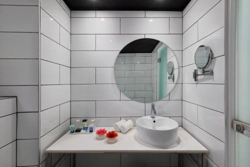 埃拉特Play Eilat Hotel的白色瓷砖浴室设有水槽和镜子