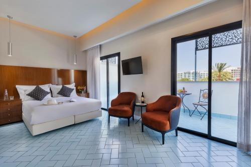 埃拉特Play Eilat Hotel的酒店客房,配有一张床和两把椅子