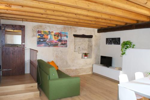 维托里奥·威尼托Residence Porta Della Muda的客厅配有绿色椅子和电视