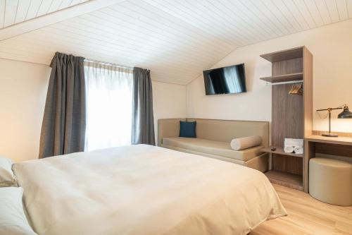 OlivoneRelais Lucomagno的一间卧室配有一张床、一张沙发和一个窗口