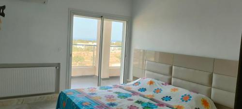 哈马马特Appartement Haut Standing à Hammamet - Tunisie的一间卧室设有一张床和一个大窗户