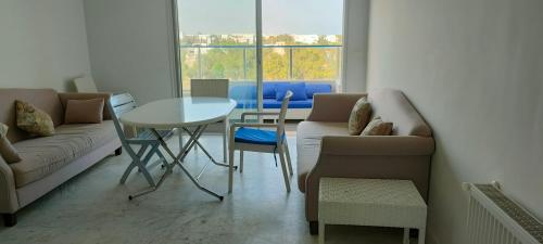哈马马特Appartement Haut Standing à Hammamet - Tunisie的客厅配有沙发和桌椅