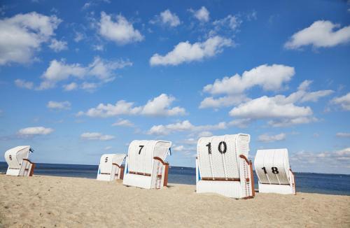 赫亨基尔兴Bades Huk Ferien-Resort的海滩上一排沙滩椅