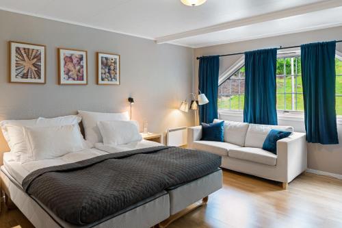 FiskåMoens Motell的一间卧室配有一张床、一张沙发和一个窗口