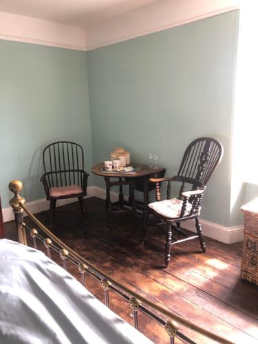 布里德波特The Victorian House的卧室配有两把椅子、一张桌子和一张床
