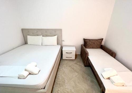 卡萨米尔Guesthouse Siars的小客房内的两张床,配有白色床单