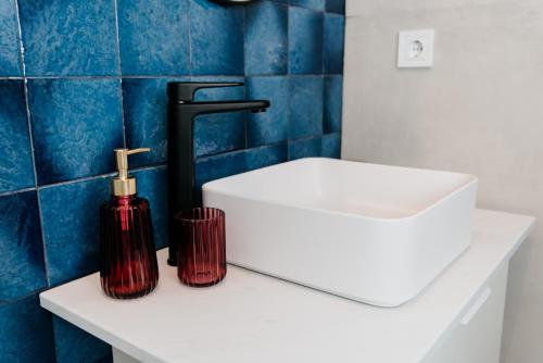 克卢日-纳波卡Evo Residence Migdalului的浴室设有白色水槽和柜台上的红色瓶子
