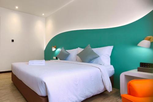 古晋Kuching Park Hotel的一间卧室设有一张大床和绿色的墙壁
