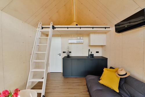 库雷萨雷Unique Tiny House at Saaremaa Golf & Country Club的带高架床和厨房的客房