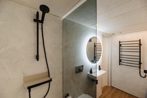 库雷萨雷Unique Tiny House at Saaremaa Golf & Country Club的带淋浴、盥洗盆和镜子的浴室