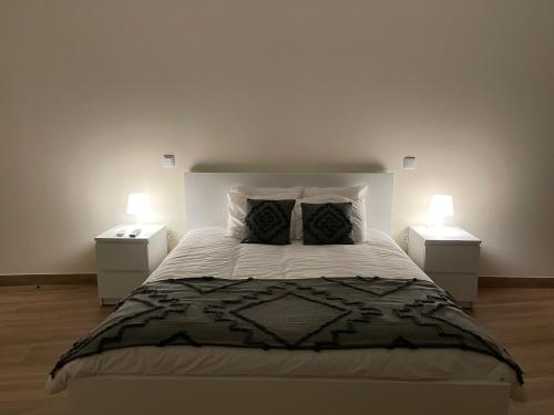 维拉·雷阿尔Quinta da Menina Guest House的一间卧室配有一张带2个床头柜的大床