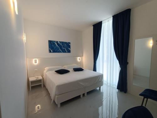 奇维塔韦基亚Hotel Smart Cruise的卧室配有白色的床和窗户。