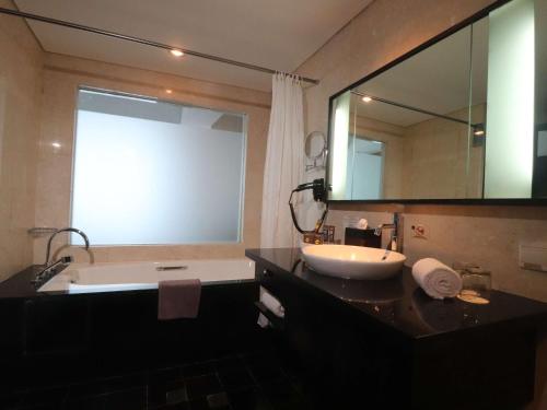 巴厘巴板巴厘巴班诺富特酒店的带浴缸、水槽和镜子的浴室