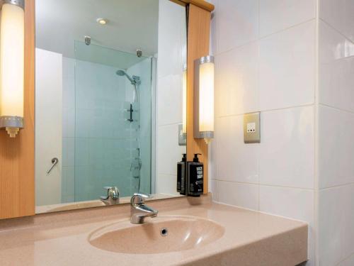 约克宜必思约克中心酒店的一间带水槽和玻璃淋浴的浴室