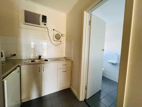 格莱内尔格1BR at Moseley st Glenelg 30的一间带水槽和微波炉的小厨房