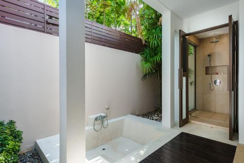 班拉克海滩Bacaya Beachfront Villa的一间带浴缸和淋浴的浴室,并设有一个窗户