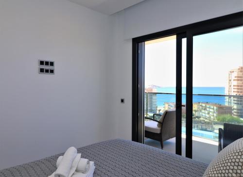 贝尼多姆Sunset Drive Resort Apartment 5-10 Poniente Beach的一间卧室配有一张床,享有海景