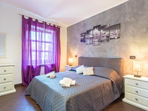 里沃利Castle Suite - centro storico的一间卧室配有一张大床和紫色窗帘