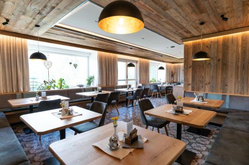 拉姆绍达赫斯坦Sonnenhügel的配有木桌和椅子的餐厅
