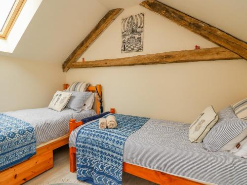 比尔斯韦尔斯Buzzards Breg的一间卧室设有两张床和横梁天花板。