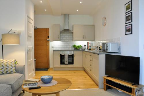特尔福德Crescent House Apartments的厨房以及带沙发和桌子的客厅。