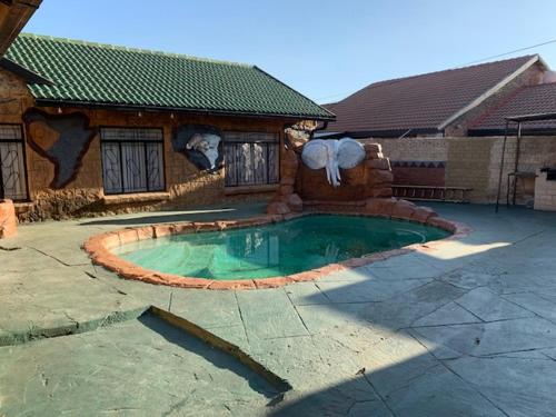 布龙克霍斯茨普雷Sikhula Sonke Guest House的庭院中带游泳池的房子