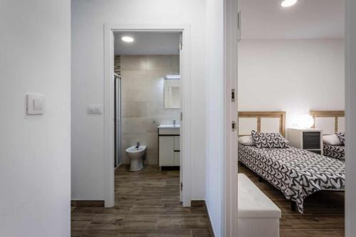 穆尔西亚Nuevo apartamento en bahia de mazarron的一间卧室配有一张床,浴室设有水槽
