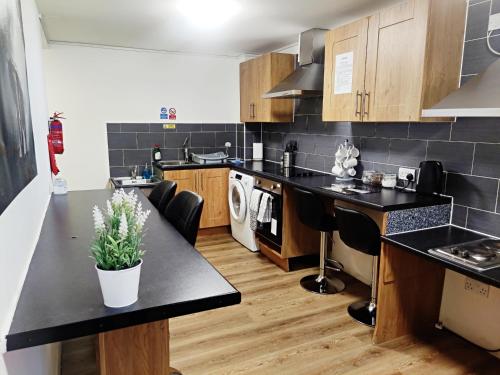 布雷得佛Accommodation Bradford的厨房配有黑色台面和黑色台面
