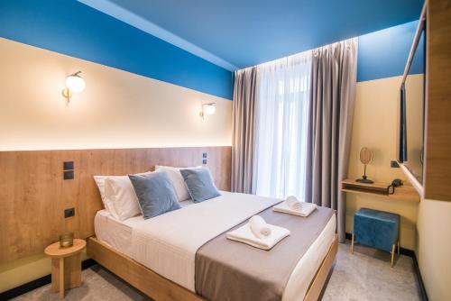 雅典Metis Urbane Living Spaces的一间卧室设有一张带蓝色墙壁和窗户的大床
