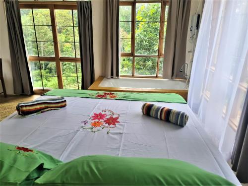 阿鲁沙Holiday cottage by the river, Arusha的一张床上的白色毯子,上面有鲜花