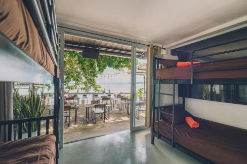 苏梅岛Chill Inn Lamai Hostel & Beach Cafe的客房设有双层床和带桌子的阳台。