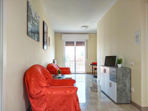 摩德纳Casa Bignardi - Affitti Brevi Italia的客厅配有红色椅子和电视