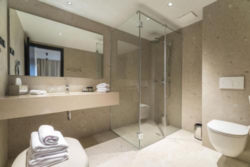 赫瓦尔Beach Bay Hvar Hotel的带淋浴、卫生间和盥洗盆的浴室