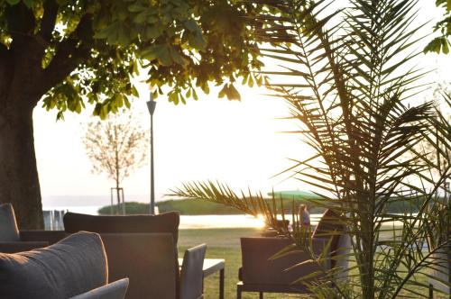 滨湖波德斯多夫赫林德湖滨酒店的一个带桌椅的庭院和棕榈树
