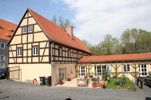 MüglitztalFachwerkhaus Maxen的一座古老的建筑,房子前面有一个庭院