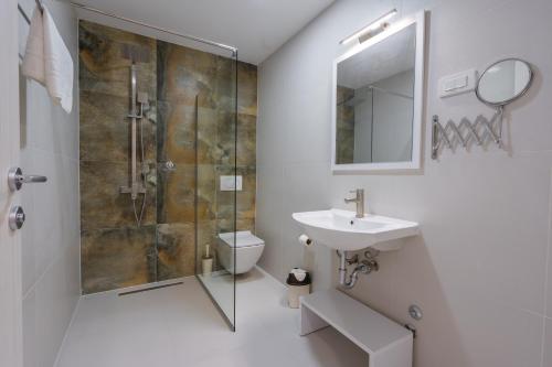 斯科普里Hotel & Resort Bon Bon的带淋浴、盥洗盆和卫生间的浴室