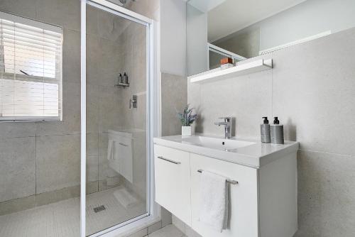 开普敦Century City Luxury Two Bedroom Apartment的白色的浴室设有水槽和淋浴。