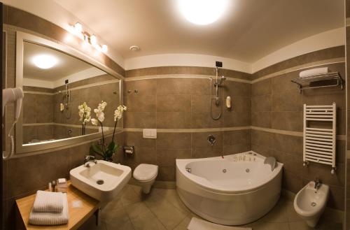 博洛尼亚伯格纳大都会酒店的一间带大浴缸和水槽的浴室