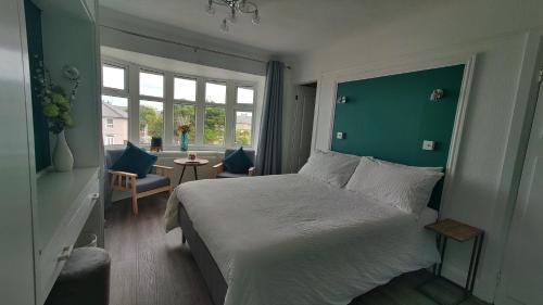 霍利黑德Orient B&B的一间卧室设有一张大床和绿色的墙壁