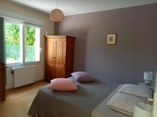 布尔日Le jardin d'Anatole的一间卧室配有一张带两个粉红色枕头的床