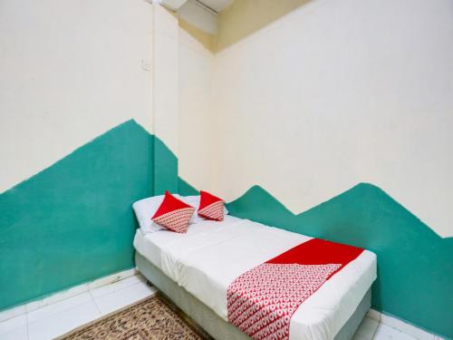 JodohSPOT ON 91512 Siantan Anambas Syariah的一间卧室配有一张带红色枕头的床