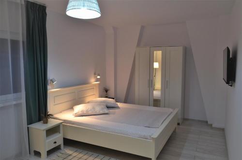克里尚Casa Calin的白色卧室配有一张带镜子的床