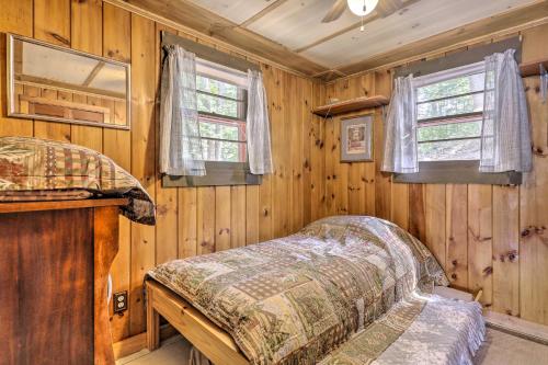 SanborntonLake Hermit Cabin with Kayaks and Paddleboards!的木制客房内的一间卧室,配有一张床
