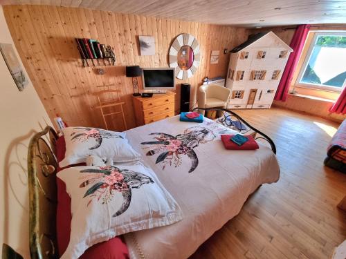 PluméliauTy Cosy, Chambre privée的一间卧室配有一张床,并在一间客房内配有电视。