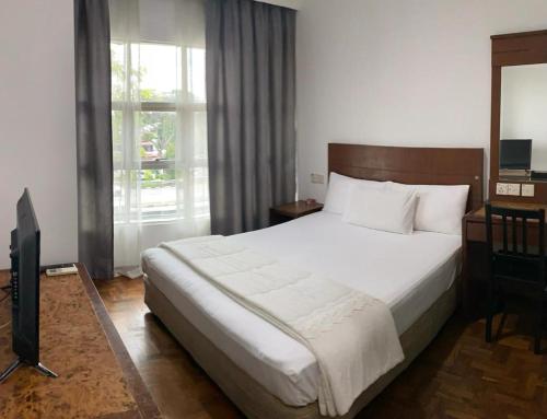 新山EE HOTEL Johor Jaya的一间卧室配有一张大床和电视