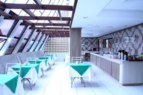 阿拉皮拉卡Hotel Nacional的餐厅设有绿色和白色的桌子和柜台