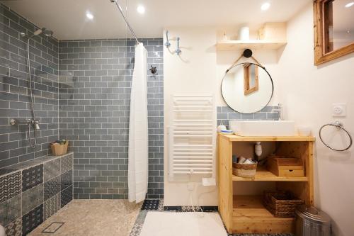 拜兰特里Casa MaMa&ly的浴室铺有蓝色瓷砖,配有水槽和淋浴。